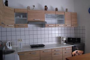 a kitchen with wooden cabinets and a counter top at Ferienwohnung Rose in Schöneck