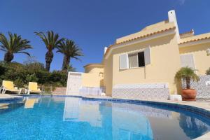 a villa with a swimming pool in front of a house at Villa Carvoeiro Ceu in Lagoa +21 photos