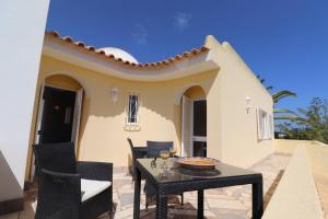 a patio with a table and chairs in front of a house at Villa Carvoeiro Ceu in Lagoa