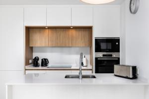 a white kitchen with a sink and a microwave at Horus 051 in Torre del Mar