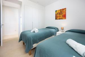 two beds in a white room with green sheets at Horus 051 in Torre del Mar +18 photos