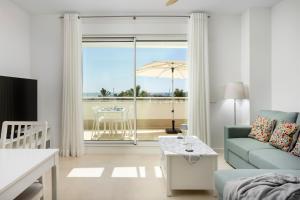 a living room with a couch and a table with an umbrella at Horus 051 in Torre del Mar