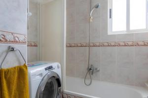 a washing machine in a bathroom next to a shower at Costamar Oceanview 1 Bed Apartment in Arona