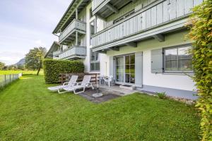 a house with two chairs and a table in the yard at Fewo Brünnstein - Nr 13 Pool, Sauna in Oberaudorf