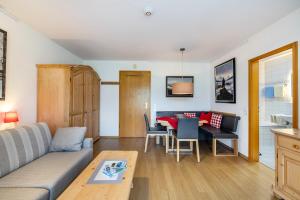 a living room with a couch and a table at Fewo Brünnstein - Nr 13 Pool, Sauna in Oberaudorf