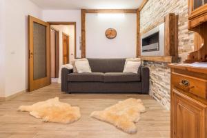 a living room with a couch and a brick wall at Casa Ferrazza Michelle in Madonna di Campiglio