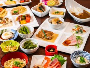 a table with many plates of food on it at Lit Hotel NAKIJIN in Nakijin