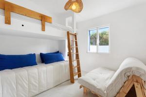 a bedroom with a bunk bed with blue pillows and a ladder at Casa da Praia Valmitão in Ribamar