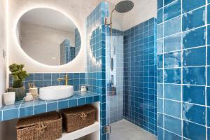 a blue tiled bathroom with a sink and a mirror at Casa da Praia Valmitão in Ribamar +22 photos