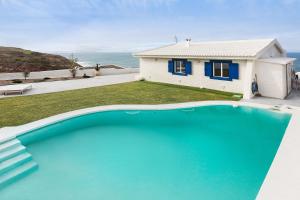 a house with a large swimming pool in front of a house at Casa da Praia Valmitão in Ribamar