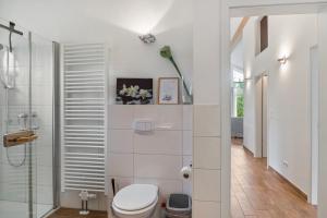 a bathroom with a toilet and a glass shower at Rosenuferhaus in Kosel +22 photos
