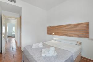 a bedroom with a bed with towels on it at Con piscina en playa Islantilla in Islantilla +21 photos
