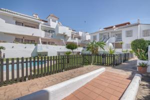 a fence in front of some apartment buildings at Con piscina en playa Islantilla in Islantilla