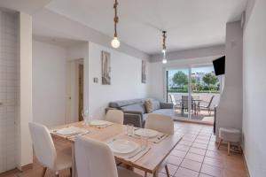 a dining room and living room with a table and chairs at Con piscina en playa Islantilla in Islantilla