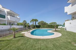a swimming pool in a yard next to a house at Con piscina en playa Islantilla in Islantilla