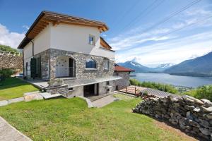 a house on a hill with a view of a lake at Il Nido Del Colibrì in Stazzona