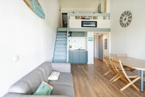 a living room with a couch and a table at Superbe Appartement Vue Océan in Capbreton