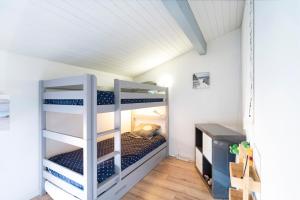 a bedroom with bunk beds in a room with a desk at Superbe Appartement Vue Océan in Capbreton