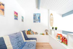 a living room with white walls and a blue couch at Superbe Appartement Vue Océan in Capbreton