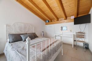 a bedroom with a white bed and a desk at Il Nido Del Colibrì in Stazzona