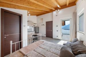 a bedroom with a large bed and a kitchen at Il Nido Del Colibrì in Stazzona