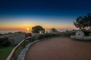 a sunset over the ocean with a brick walkway at Casa 2 in Castiadas