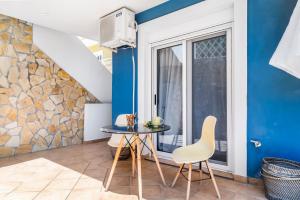 a small table and chairs in a room with a window at Oceanida Aelia Room 2 in Nikiana