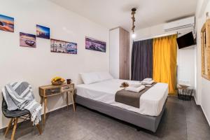 a bedroom with a bed and a desk and a chair at Oceanida Aelia Room 2 in Nikiana