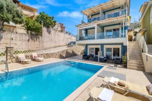 a villa with a swimming pool and a house at Oceanida Aelia Room 2 in Nikiana