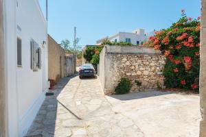 a car parked on a stone alley with flowers at Anna's Apartment Marmara Paros in Kampos Paros
