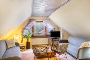 a living room with a couch and chairs and a tv at Ferienhaus Felsenblick in Rippershausen