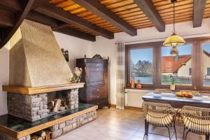 a kitchen with a stone fireplace and a table with chairs at Ferienhaus Felsenblick in Rippershausen +12 photos