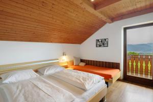 a bedroom with two beds and a large window at Harmony Apt 2 in Appiano sulla Strada del Vino