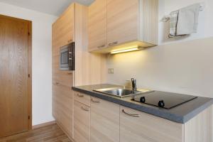 a kitchen with a sink and wooden cabinets at Harmony Apt 2 in Appiano sulla Strada del Vino +36 photos