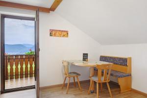 a table and chairs in a room with a balcony at Harmony Apt 2 in Appiano sulla Strada del Vino