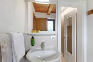 a white bathroom with a sink and a mirror at Harmony Apt 2 in Appiano sulla Strada del Vino