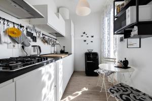 a kitchen with white cabinets and a black counter top at Villa Carla in Salò