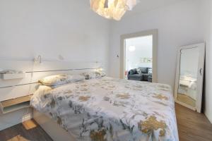 a white bedroom with a large bed with a large mirror at Villa Carla in Salò