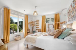 a bedroom with a large bed and a large window at Appartement Le Figuier in Fréjus +24 photos