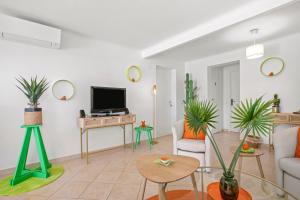 a living room with a couch and a tv at Appartement Le Figuier in Fréjus
