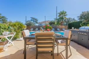 a patio with a table and chairs and a pool at Appartement Le Figuier in Fréjus
