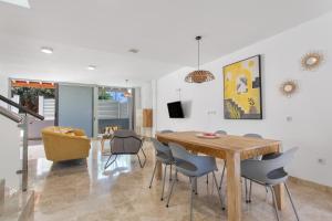 a dining room and living room with a wooden table and chairs at Casa Alicia in Corralejo