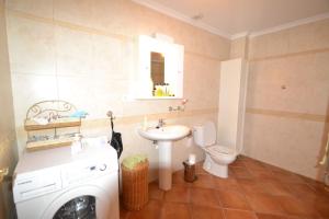 a bathroom with a washing machine and a toilet at Casa Papa in San Fulgencio +6 photos