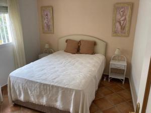a bedroom with a white bed with two night stands at Casa Papa in San Fulgencio