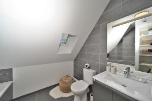 a bathroom with a white toilet and a sink at Superbe appartement - Face au lac in Génos +27 photos