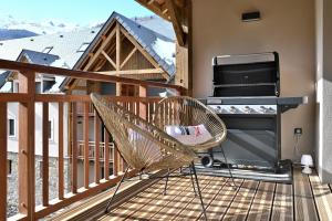 a chair sitting on a balcony with a stove at Superbe appartement - Face au lac in Génos