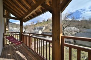 a wooden porch with a bench on a balcony at Superbe appartement - Face au lac in Génos