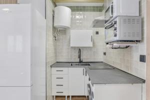 a small kitchen with a sink and a microwave at Apartamentos Habana 5 in Barbate +6 photos