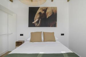 a bedroom with a bed with an elephant picture on the wall at Apartamentos Habana 5 in Barbate
