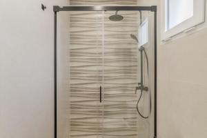 a shower with a glass door in a bathroom at Apartamentos Habana 5 in Barbate